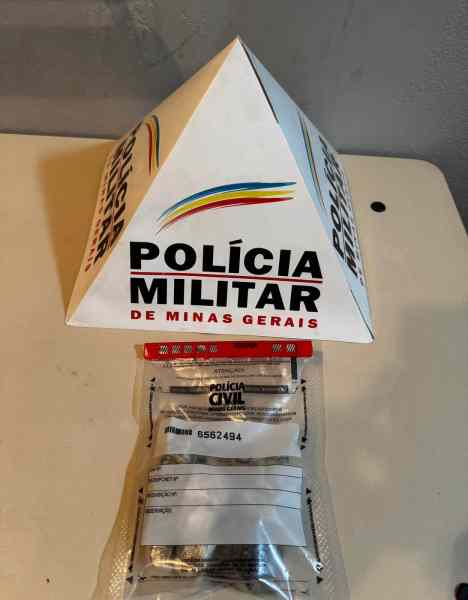 Uma estrutura em forma de pirâmide com a marca da Polícia Militar de Minas Gerais, acompanhada por pacotes que contêm drogas, identificados como pertencentes à Polícia Civil.