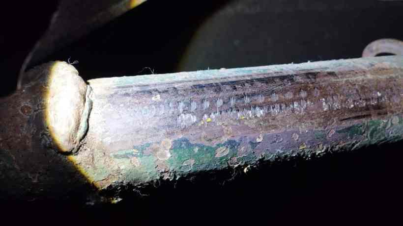 Close-up of a metal surface showing signs of grinding and lack of chassis number, indicating possible vehicle identification tampering.