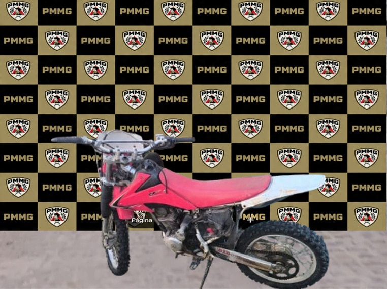 Uma motocicleta em frente a um fundo decorado com logotipos da Polícia Militar de Minas Gerais.