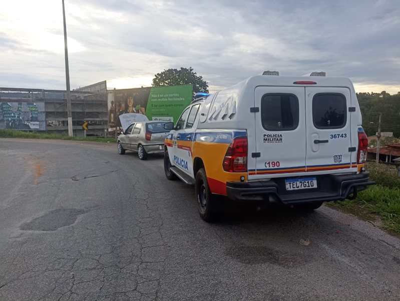 Veículo da Polícia Militar abordando um Fiat Palio durante operação de fiscalização na rodovia MG-431, com céu nublado ao fundo.