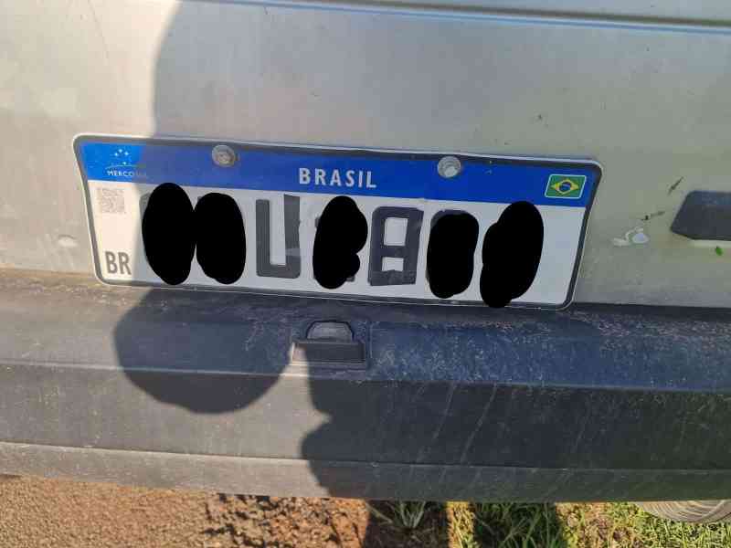 Placa de veículo Fiat Uno com indícios de adulteração, exibindo caracteres ocultos. A placa apresenta o texto 'BRASIL' e os símbolos do Mercosul.