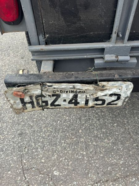 Placa de veículo com sinais de adulteração, mostrando a numeração ilegível e danificada, durante operação de fiscalização rodoviária.