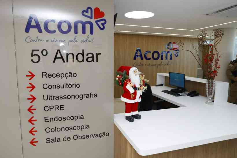 Recepção do 5º andar da Acom, incluindo sinalização para serviços como Endoscopia e Colonoscopia, com decoração natalina.