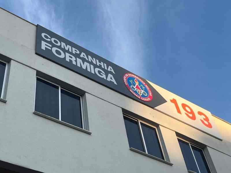 Fachada da Companhia do Corpo de Bombeiros Militar de Formiga, com a inscrição '193' e logo do corpo de bombeiros sob um céu azul.
