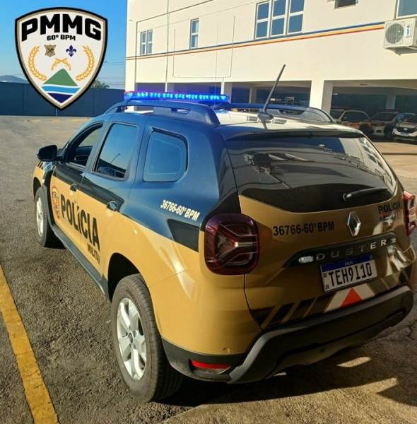 Veículo da Polícia Militar de Minas Gerais estacionado, com luzes de emergência ativadas e logo da corporação visível.