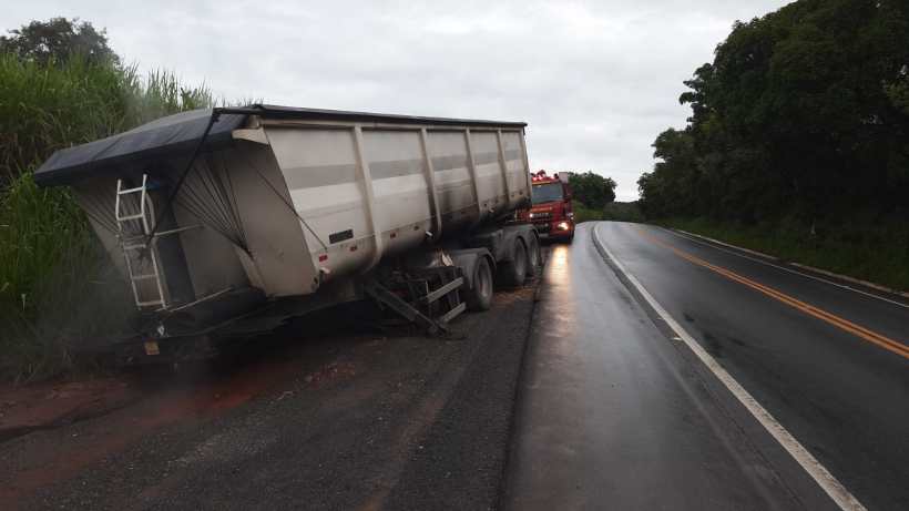 Caminhão com reboque parado à beira da estrada em um dia nublado.