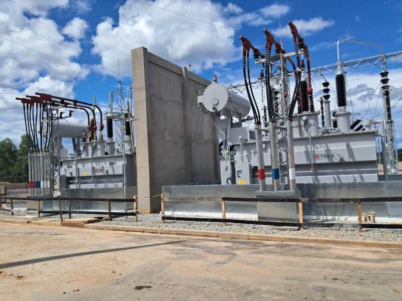 Subestação elétrica com transformadores e equipamentos de distribuição, em um dia ensolarado.