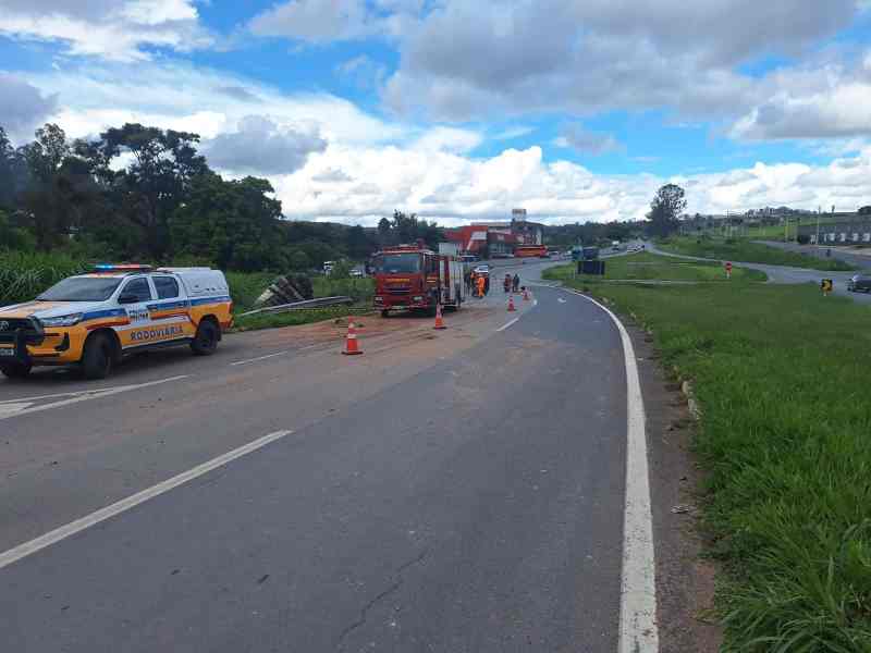 Caminho em construção com veículo da polícia rodoviária e caminhão de bombeiros presentes. Obstáculos e cones de sinalização estão espalhados na pista.