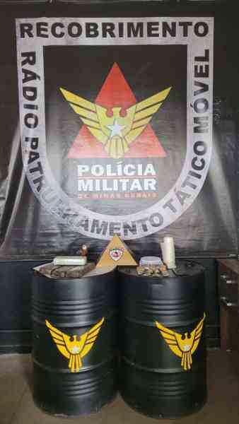 Banner da Polícia Militar de Minas Gerais com o texto 'Recobrimento Radio Patrulhamento Tático Móvel', ao fundo duas tambores pretos com o símbolo da polícia.