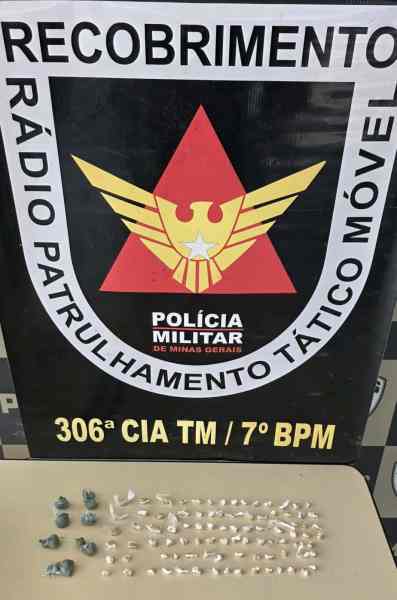 Placa da Polícia Militar de Minas Gerais com emblema e informações, acompanhada de objetos dispostos em uma mesa.