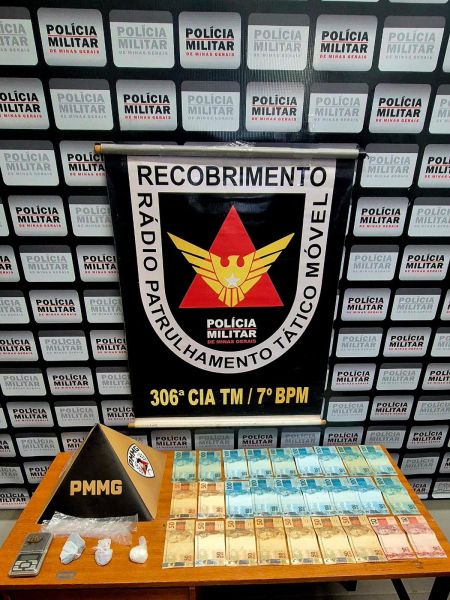 Materiais apreendidos pela Polícia Militar, incluindo dinheiro em diferentes denominações e substâncias suspeitas, com bandeira da unidade ressaltando o trabalho da polícia.