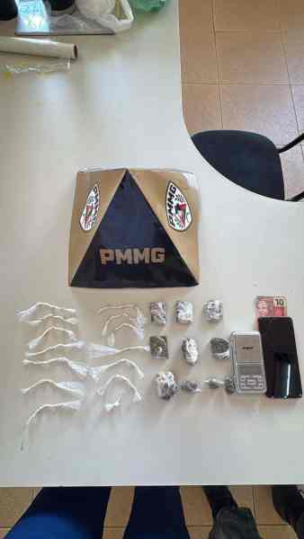 Montagem de materiais apreendidos, incluindo drogas embaladas, uma balança, um celular e uma nota de dinheiro sobre uma mesa.