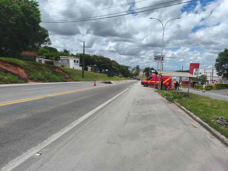 Vista de uma estrada com um veículo de emergência, sinalização de acidente e nuvens no céu.