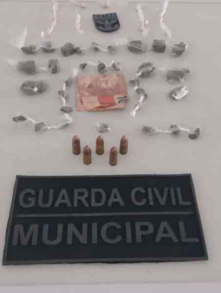 Requintos da Guarda Civil Municipal, incluindo drogas, munições e uma nota de dinheiro.
