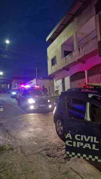 Veículos policiais em uma rua à noite, com luzes de emergência acesas, em uma área urbana.